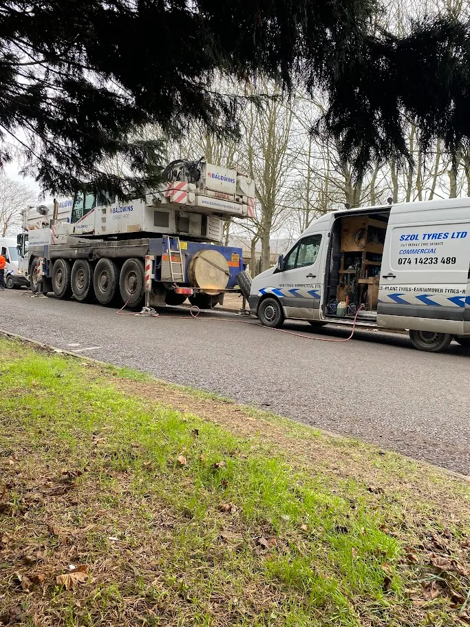 A tow truck towing a large truck down a street.