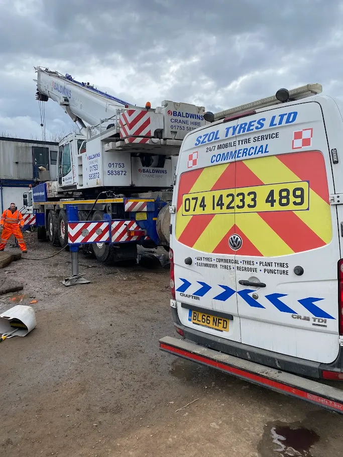 A white van parked next to a construction site.