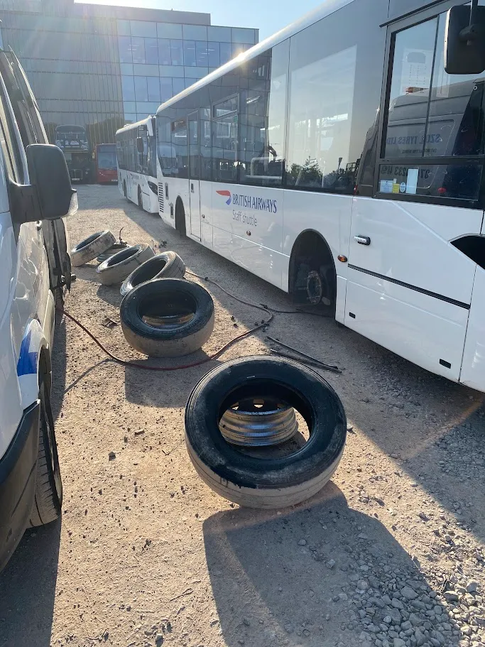 A couple of white buses parked next to each other.