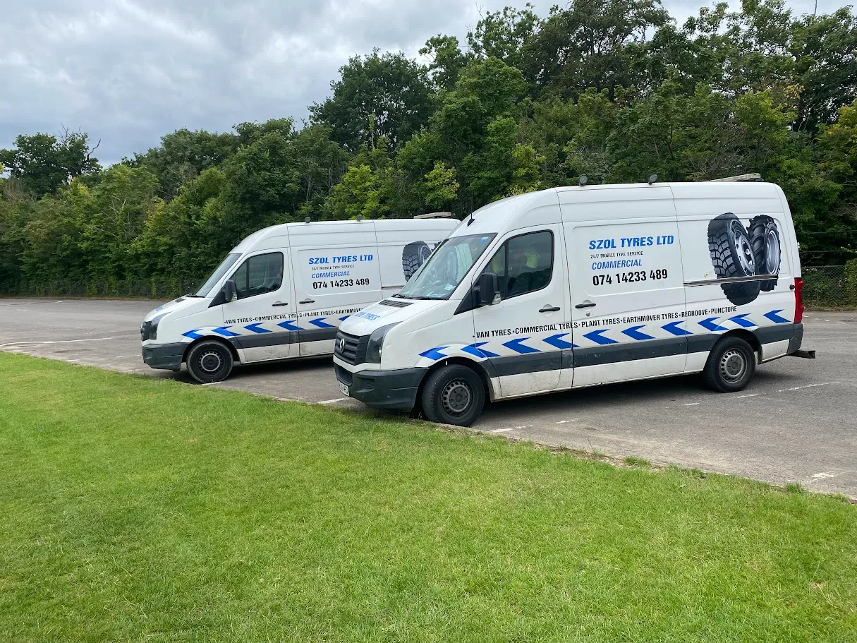 A couple of white vans parked next to each other.