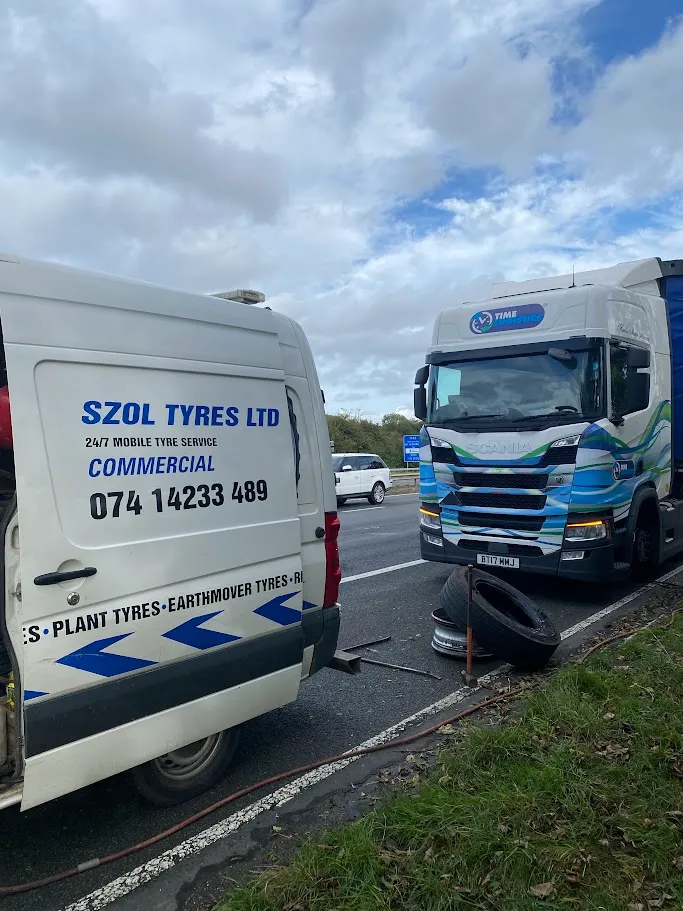 A tow truck towing a van down a road.