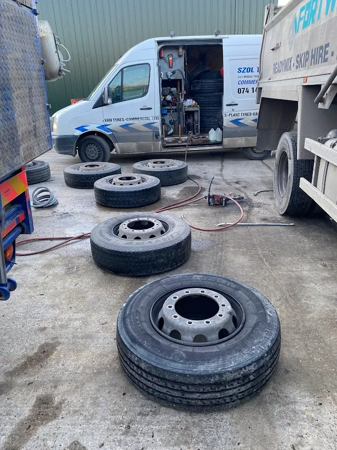 A group of tires sitting on top of a cement ground.